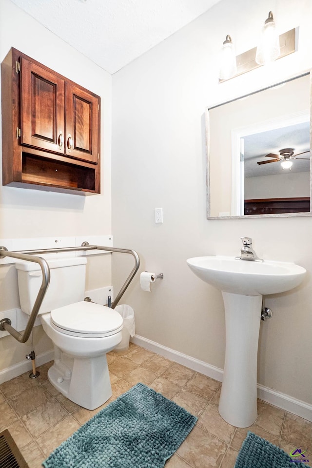 bathroom with a ceiling fan, baseboards, and toilet