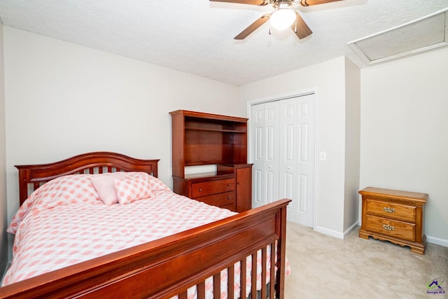 bedroom featuring ceiling fan, light colored carpet, baseboards, a closet, and attic access