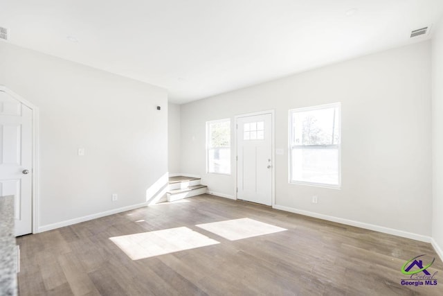 interior space with visible vents, baseboards, and wood finished floors