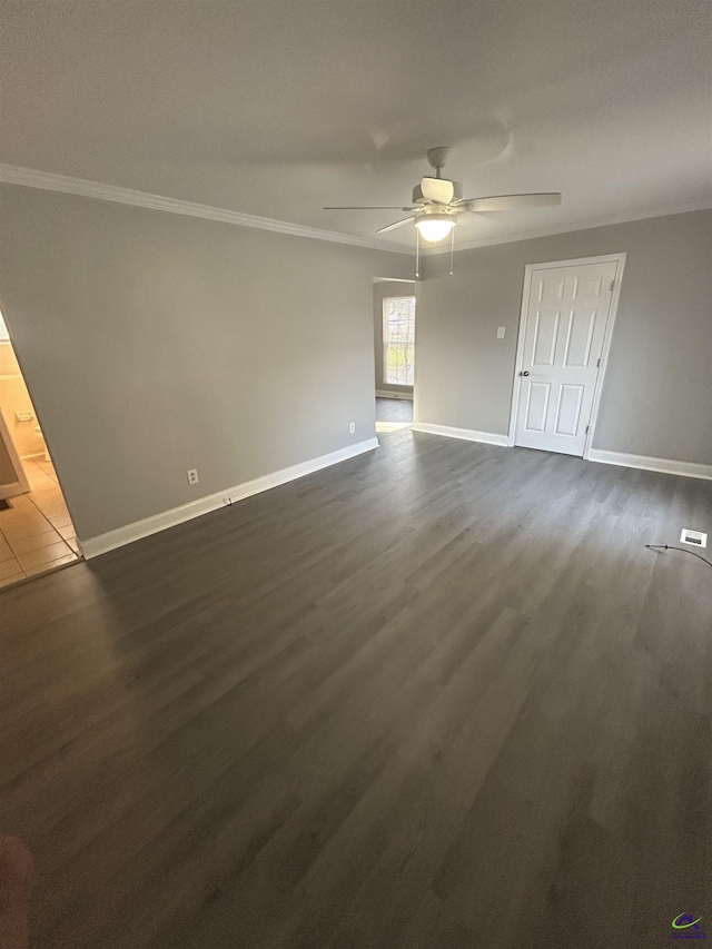 empty room with ceiling fan, dark wood-style floors, baseboards, and ornamental molding