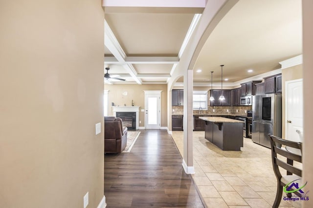 kitchen featuring tasteful backsplash, open floor plan, appliances with stainless steel finishes, dark brown cabinets, and ceiling fan