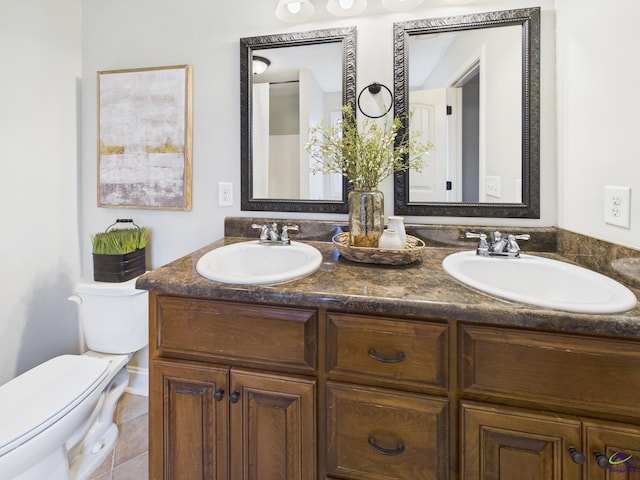 full bath featuring a sink, toilet, double vanity, and tile patterned floors