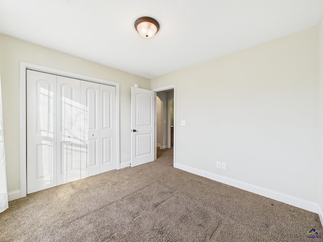 unfurnished bedroom featuring a closet, baseboards, and carpet