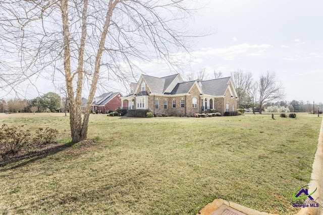 view of front of property with brick siding and a front lawn