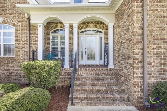 view of exterior entry featuring brick siding