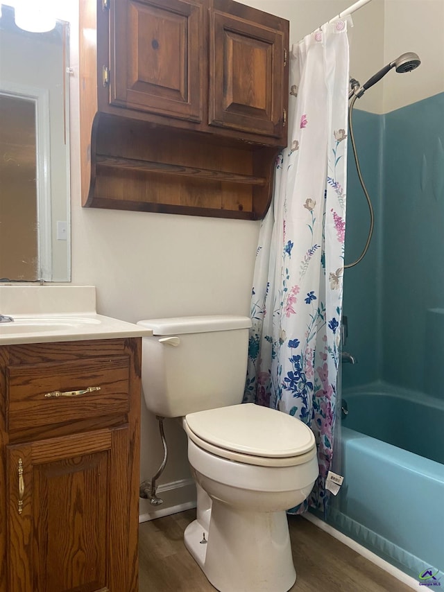 bathroom featuring shower / tub combo with curtain, wood finished floors, vanity, and toilet