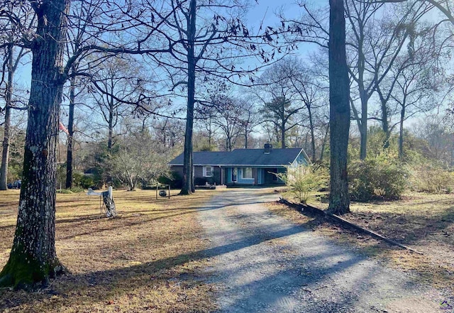 view of front of property with gravel driveway and a chimney