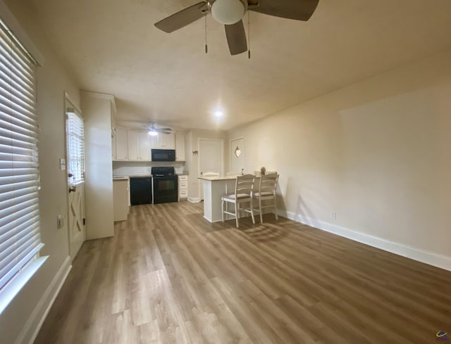 unfurnished living room featuring ceiling fan, baseboards, and wood finished floors