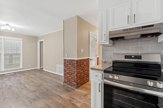 kitchen with light wood-type flooring, visible vents, under cabinet range hood, stainless steel range with electric cooktop, and white cabinets