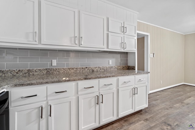 kitchen with decorative backsplash, light wood-style floors, ornamental molding, and white cabinetry