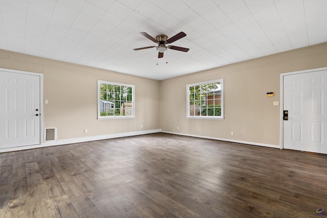 unfurnished living room with baseboards, visible vents, dark wood-style flooring, and ceiling fan