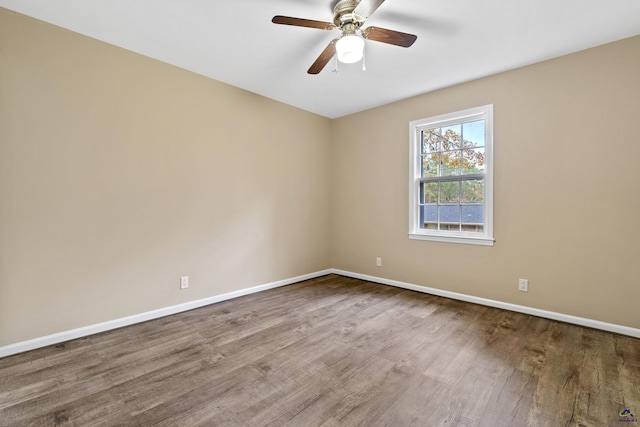 empty room with a ceiling fan, baseboards, and wood finished floors