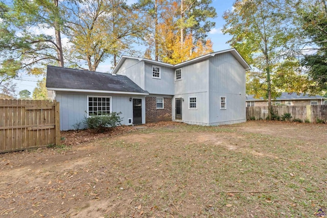 rear view of property with fence and brick siding