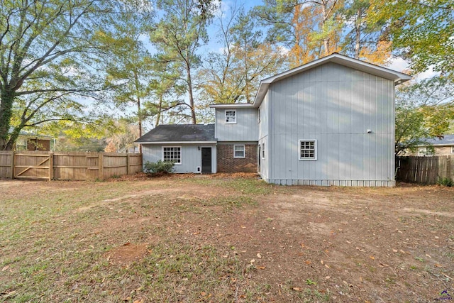 back of house featuring brick siding and fence