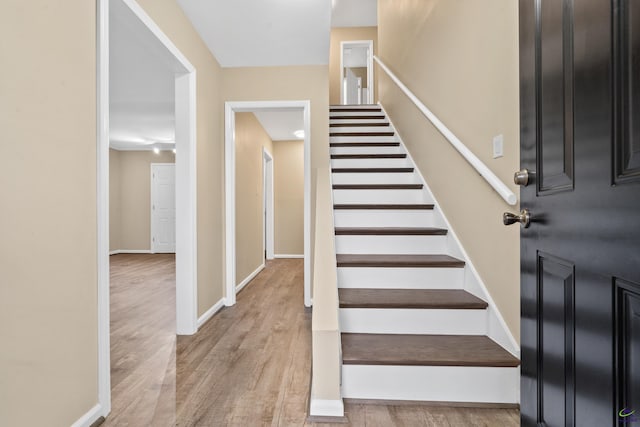 stairway with baseboards and wood finished floors