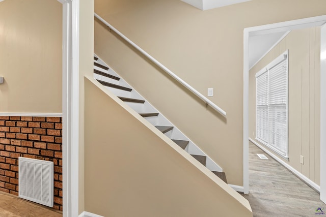 stairway featuring visible vents and wood finished floors