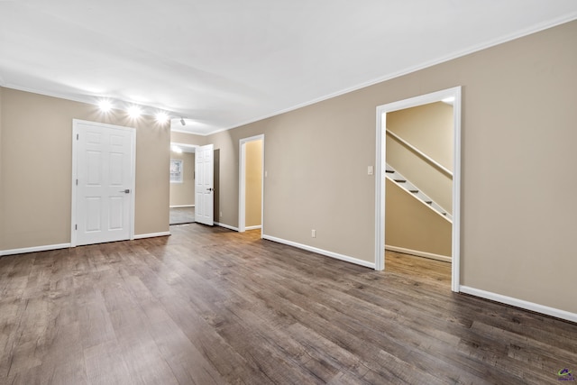 unfurnished room featuring crown molding, wood finished floors, and baseboards