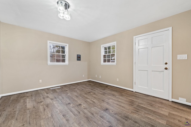 unfurnished room featuring baseboards and wood finished floors