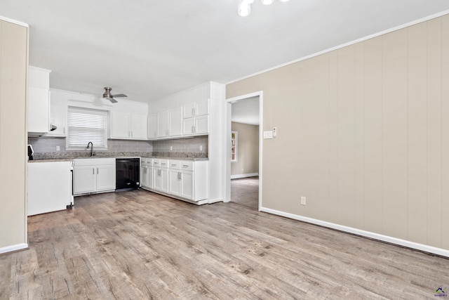 kitchen featuring tasteful backsplash, light wood finished floors, white cabinetry, a ceiling fan, and a sink