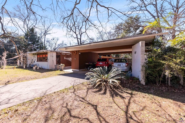 mid-century inspired home with concrete driveway and a front yard