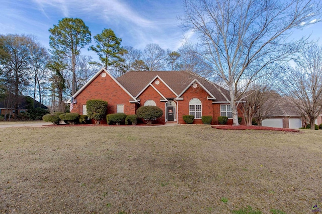 view of front of property featuring a front yard, brick siding, and a shingled roof