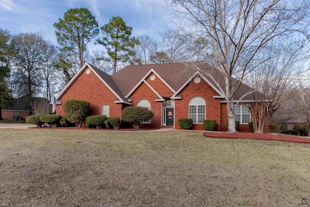 view of front facade featuring brick siding and a front yard