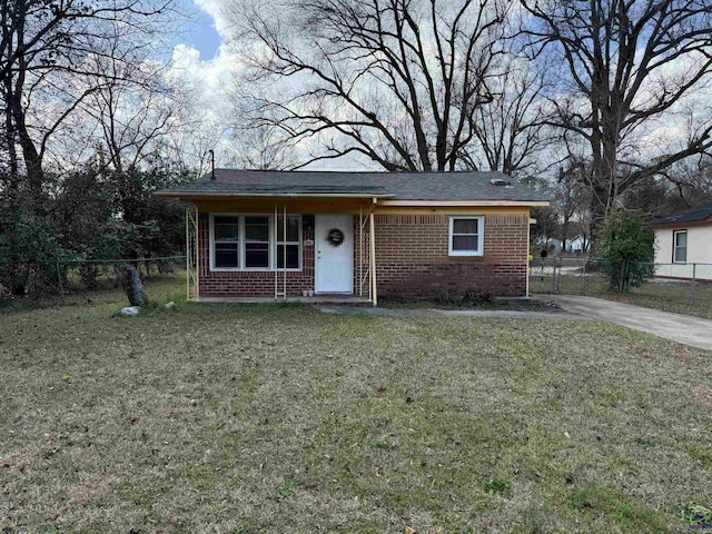 view of front of home with a front yard, fence, and brick siding