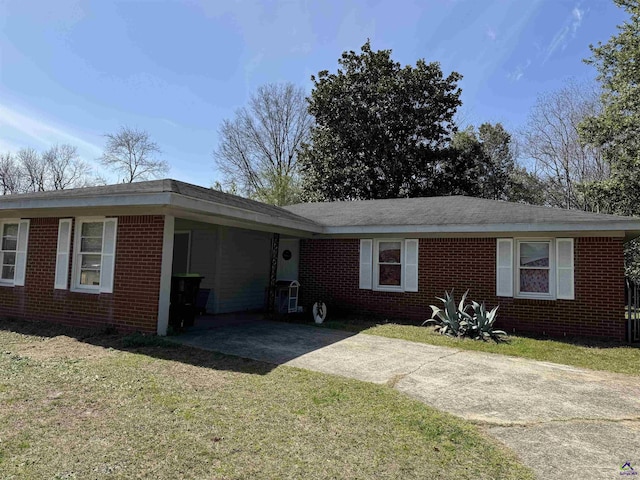 ranch-style house featuring a front lawn, brick siding, and driveway