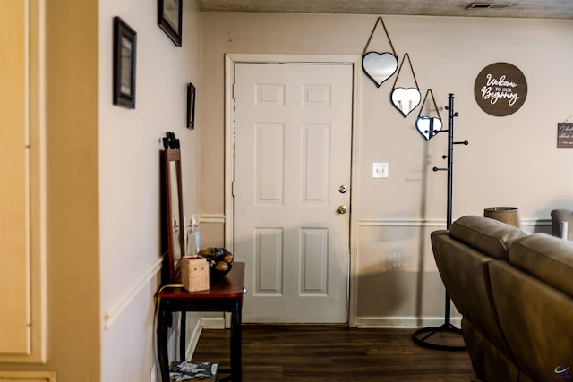 foyer entrance with visible vents and dark wood-style flooring