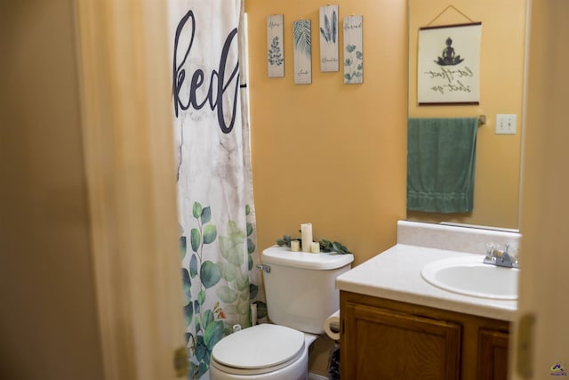 bathroom featuring vanity, curtained shower, and toilet