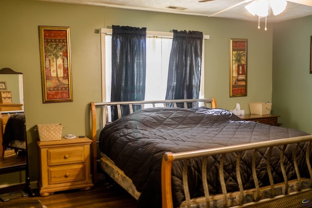 bedroom featuring visible vents and dark wood-style floors