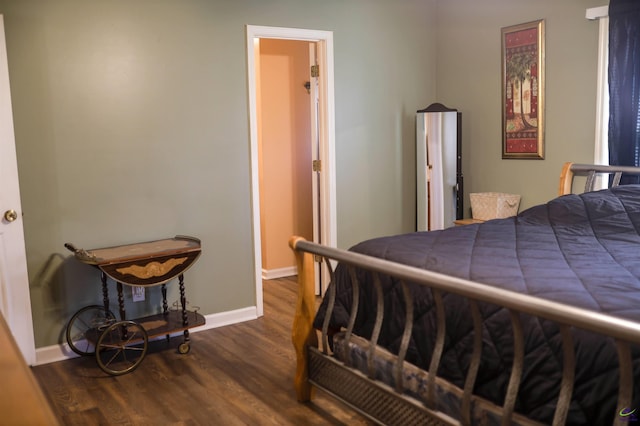 bedroom with baseboards and dark wood-style flooring