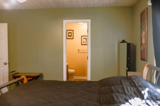 bedroom featuring connected bathroom and a textured ceiling