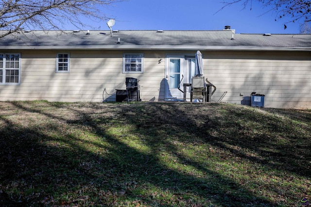 rear view of house featuring a yard