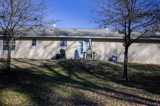 rear view of house featuring a yard