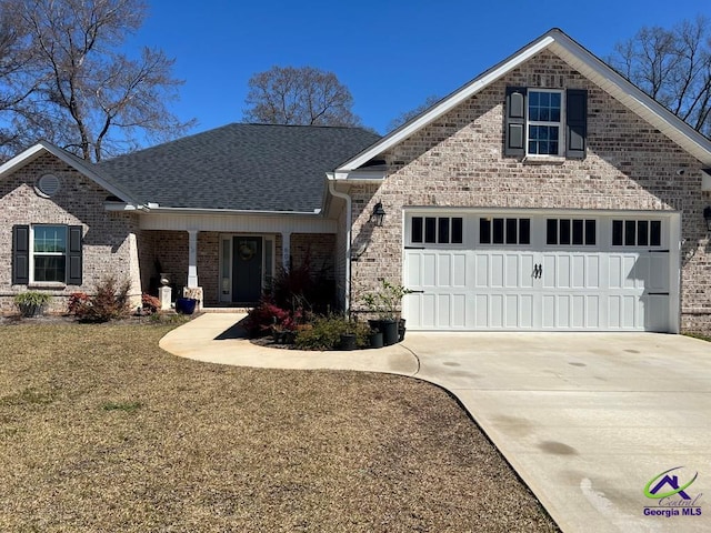 view of front facade featuring brick siding, an attached garage, concrete driveway, and a shingled roof