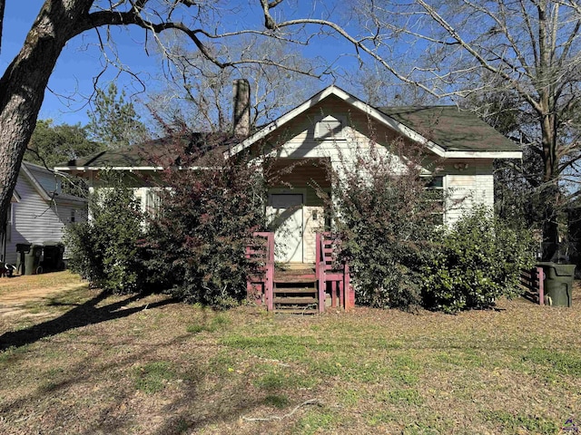 rear view of house featuring a lawn