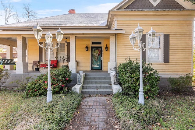 property entrance featuring brick siding and covered porch