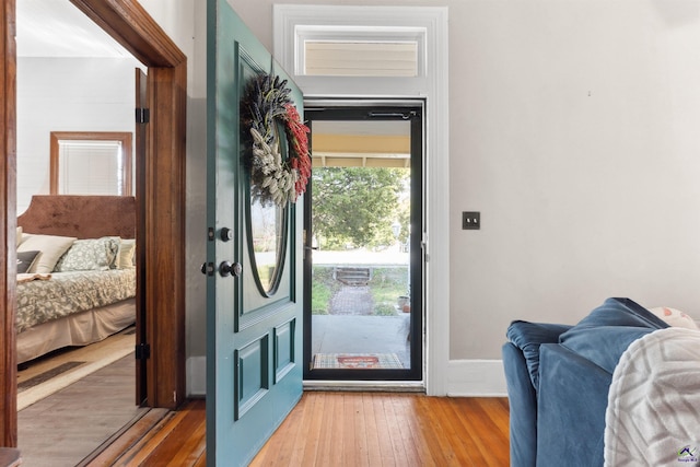 doorway with baseboards and wood-type flooring