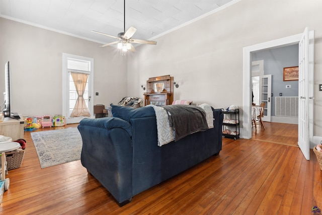 living area featuring a ceiling fan, hardwood / wood-style flooring, and crown molding