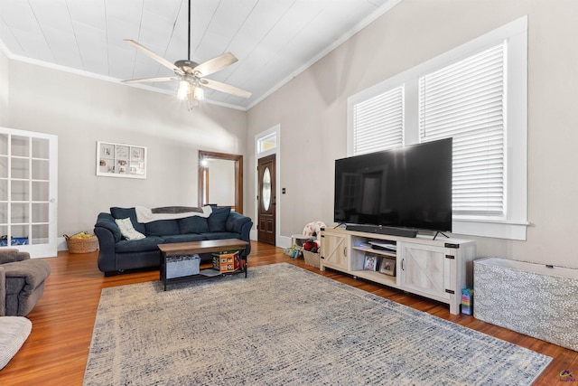 living room with wood finished floors, a ceiling fan, and ornamental molding