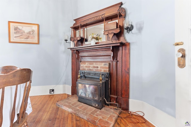 interior details with wood finished floors and a wood stove