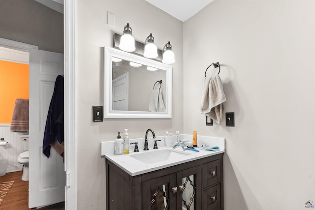 bathroom with vanity, toilet, and wood finished floors