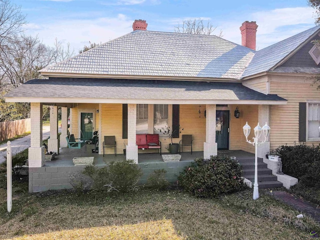 view of front of home featuring covered porch and a chimney