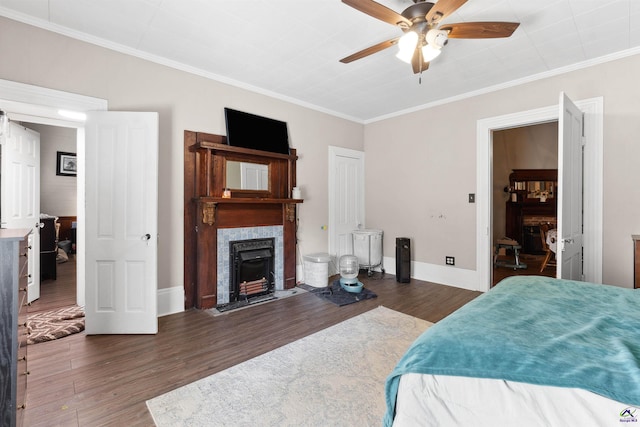 bedroom featuring a fireplace, crown molding, and wood finished floors