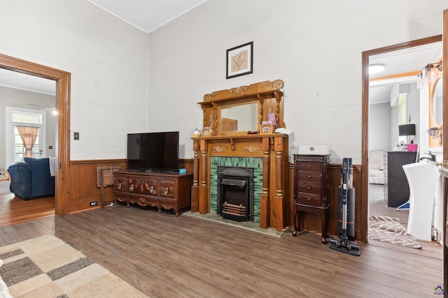 living room with wood finished floors and a tiled fireplace