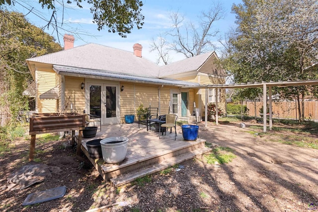 back of property featuring french doors, a deck, and fence