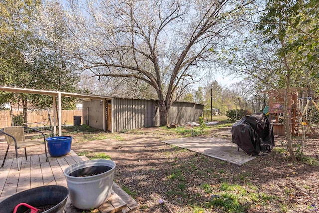 view of yard featuring a deck, an outdoor structure, and fence