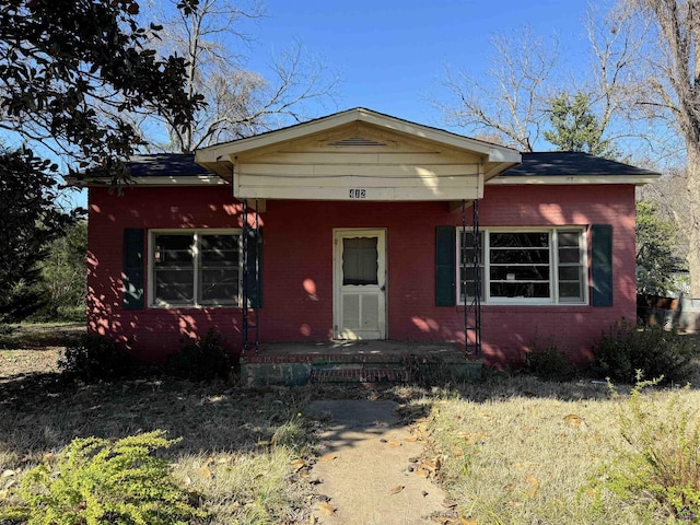 bungalow-style home featuring brick siding and covered porch