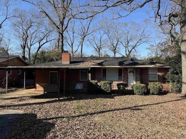 view of front of home featuring brick siding and a chimney